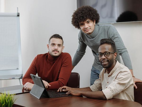 A group of office workers performing simple seated stretches together.